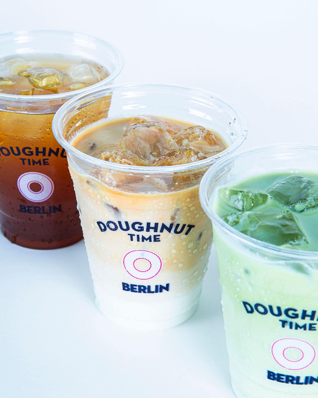 Refreshing iced drinks in Personalised Milkshake Cups with Doughnut Time Berlin branding, showcasing a variety of flavors from iced coffee to matcha.